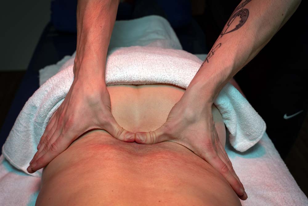 Manuelle Behandlung des Rückens eines Patienten durch einen Physiotherapeuten.