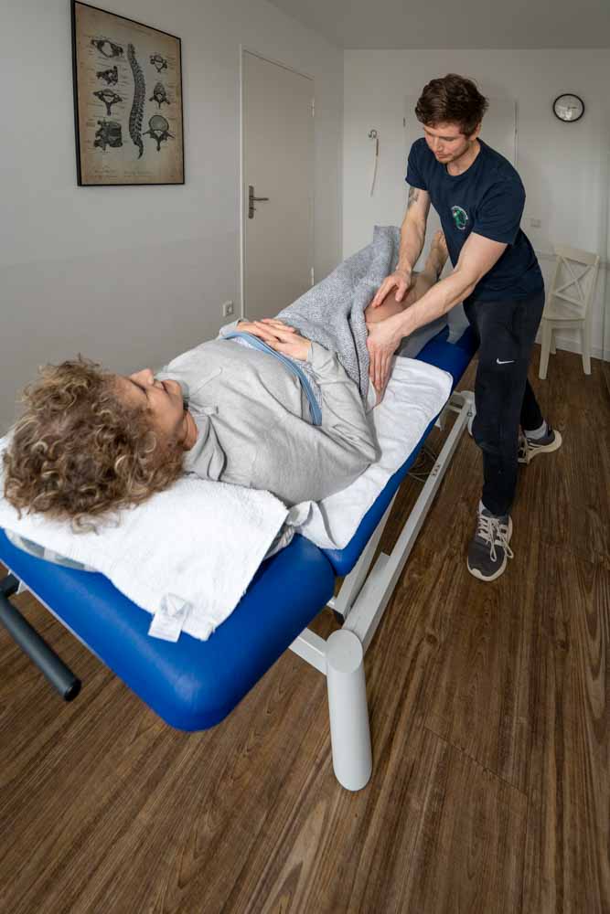 Behandlung einer Patientin auf einer Liege in der Physiotherapiepraxis.