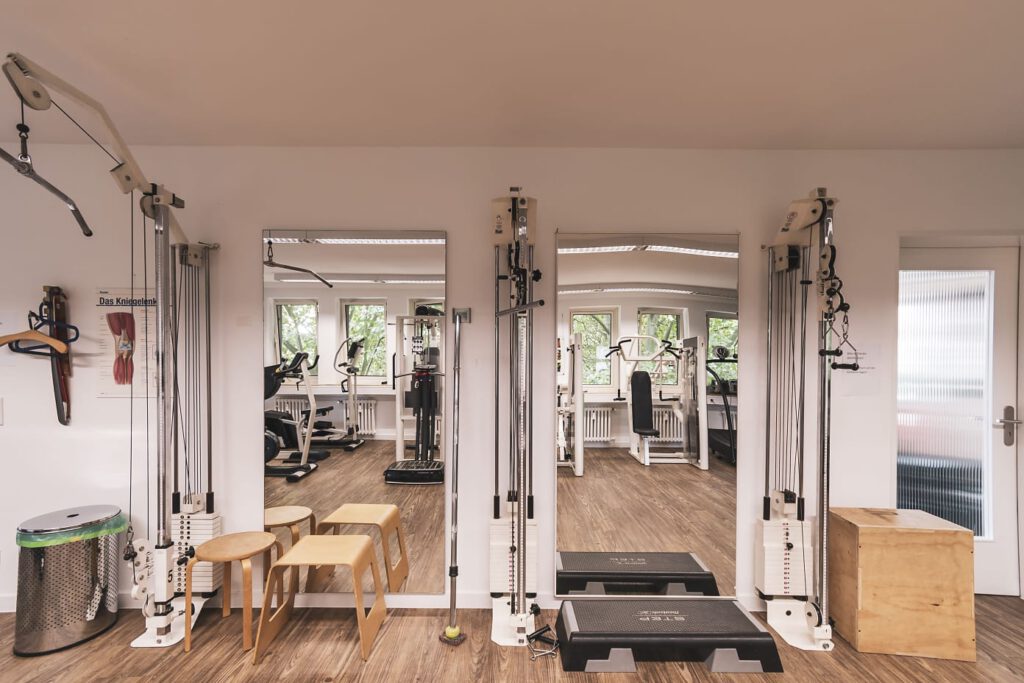 Ein Raum mit Fitnessgeräten und einem Plakat über das Kniegelenk.